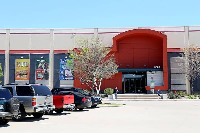 Exterior view of the National Videogame Museum in Frisco, Texas showing the modern entrance and parking area